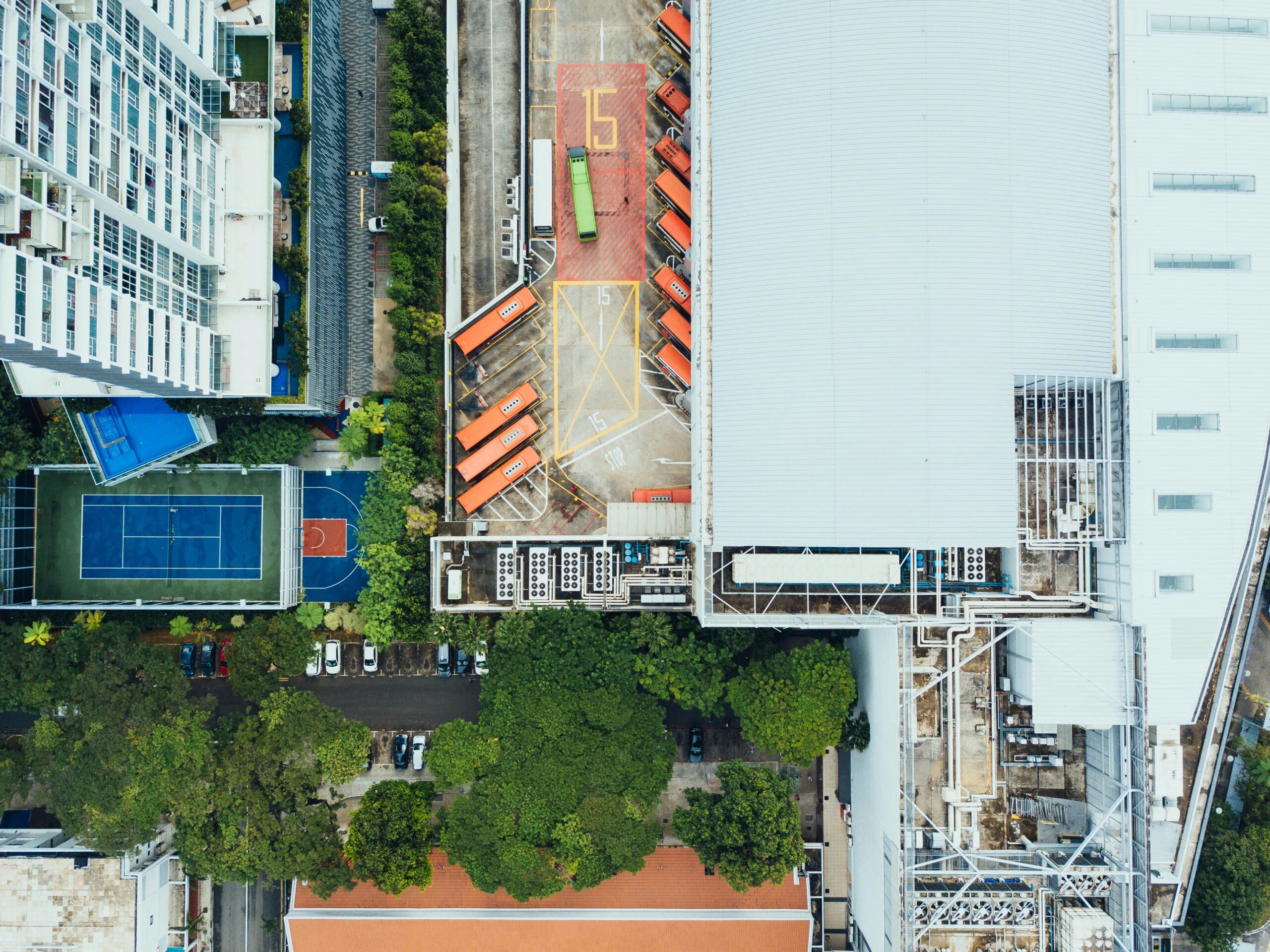 Smiling woman holding a clipboard in front of a cleaned-up industrial area