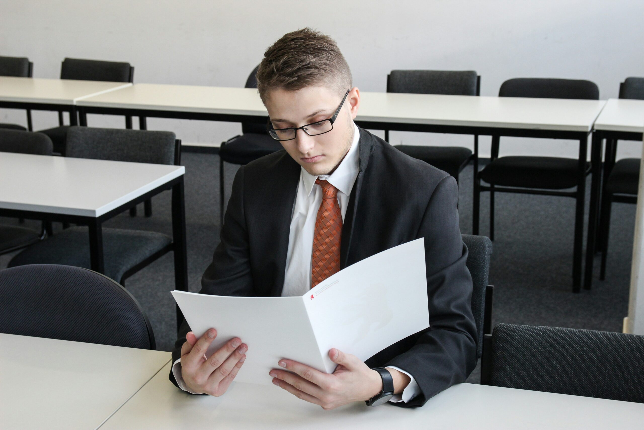 A mediator discussing documents between two parties at a table.