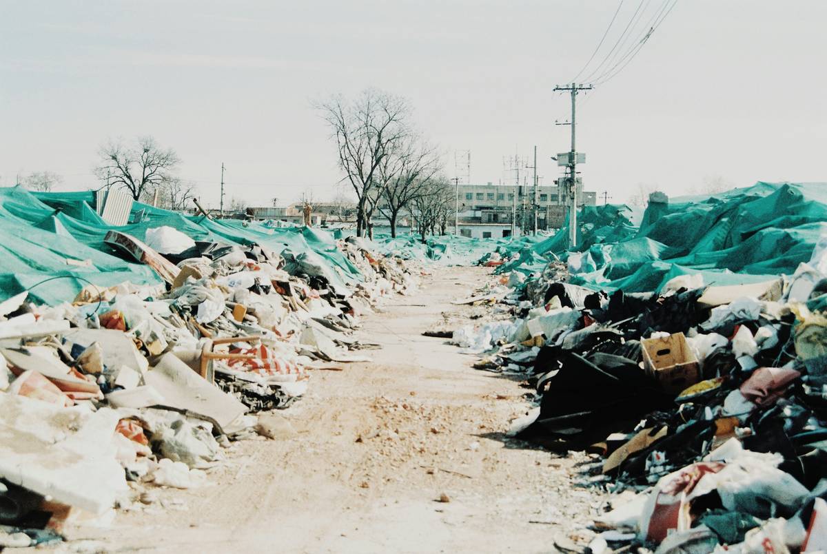 a pile of trash sitting on top of a dirt road
