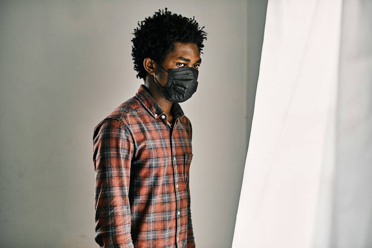 A stylish young black man wearing a black mask to prevent infections like covid19.