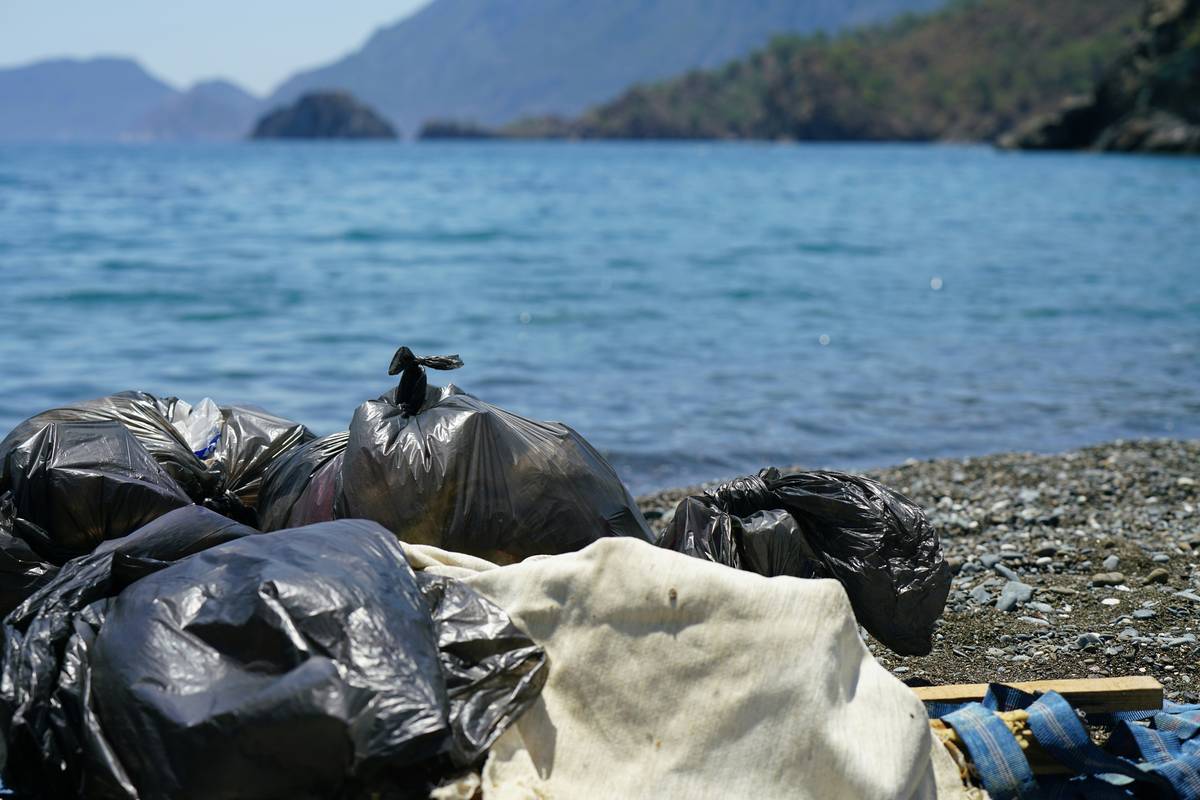 bags of collected garbage from the beach for recycling, cleaning the beach from pollution, sea view