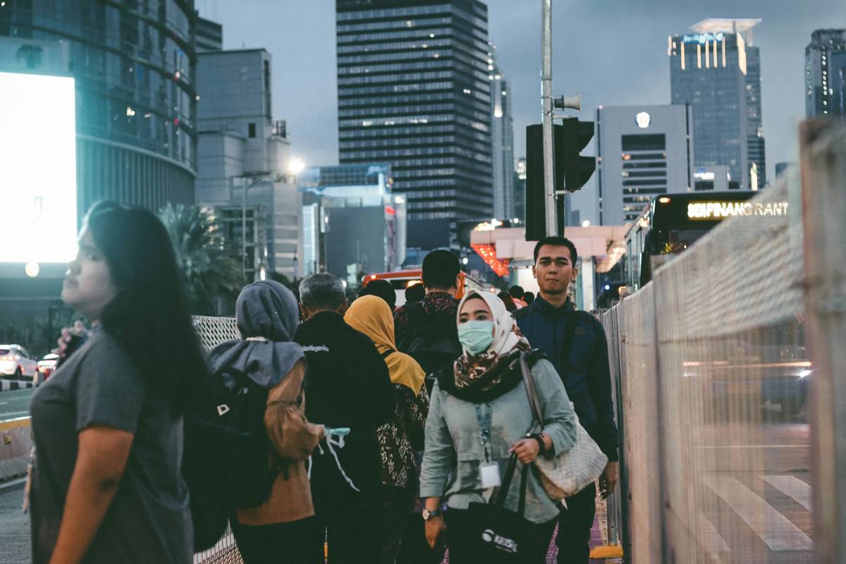 Pedestrian enter and quit the bus stop on Jenderal Sudirman Street.